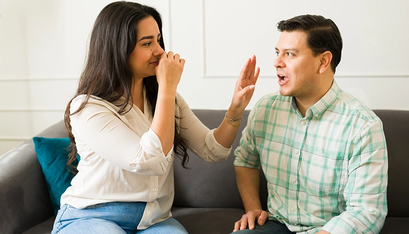 hombre_con_halitosis_y_mujer_detectando_mal_aliento.webp