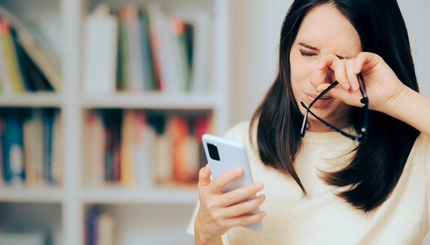 Mujer frotándose los ojos por picor ocular debido al uso prolongado de pantallas..webp