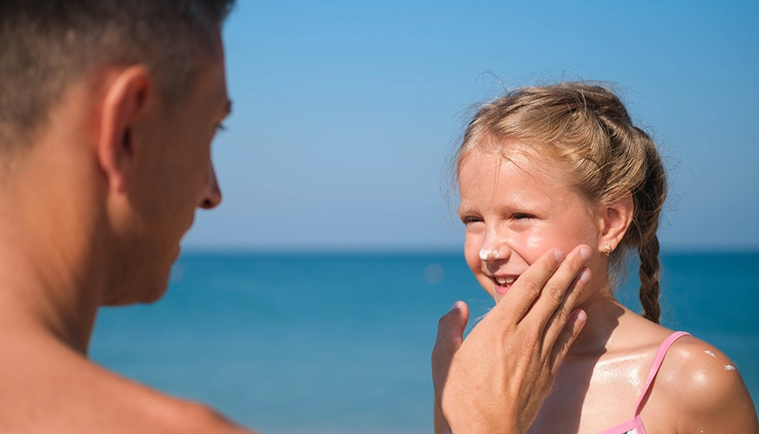 padre_aplicando_protector_solar_hija.webp